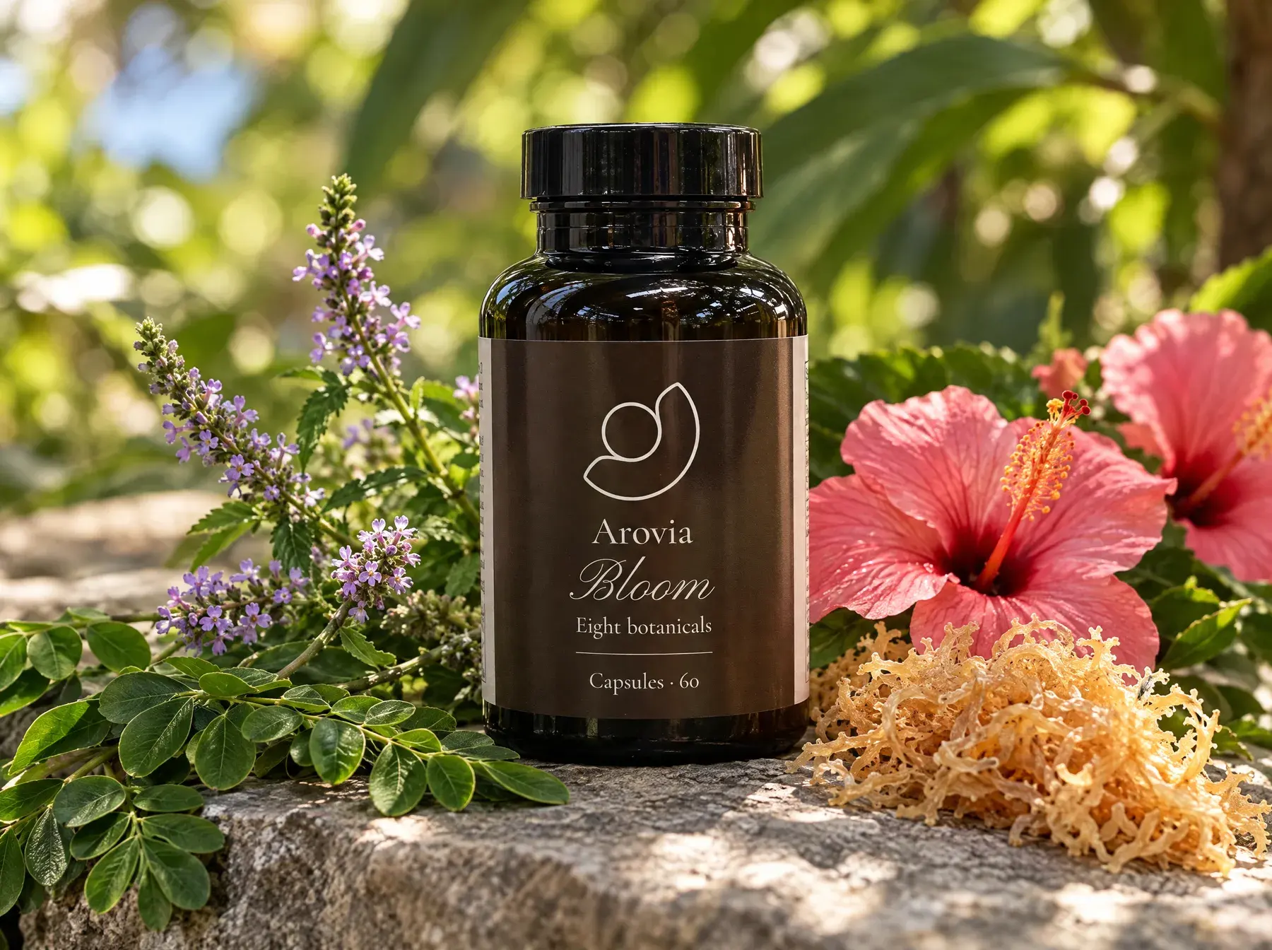 Arovia Bloom bottle on stone among vervain, moringa, hibiscus and sea moss